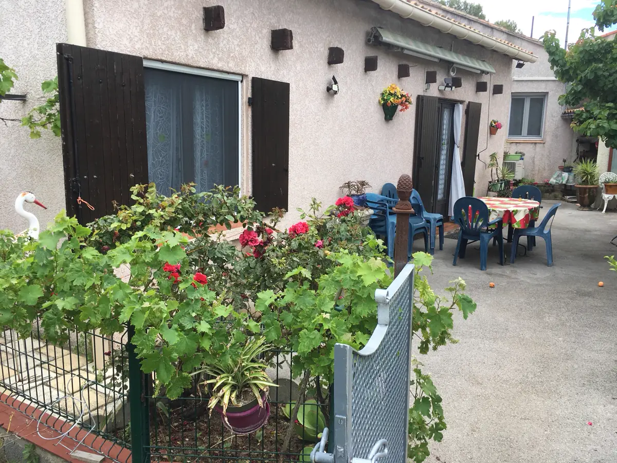 Façade fleurie de la maison de l'avenue de la Gare, terrasse et salon de jardin