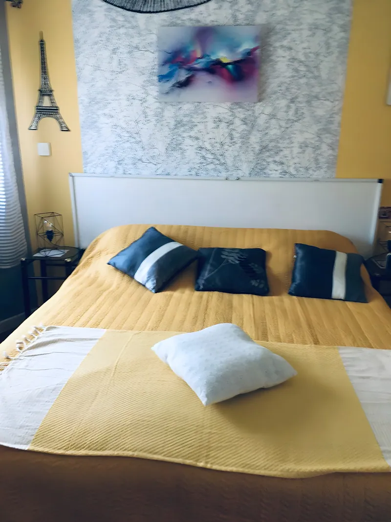Seconde chambre de L'Oustal del Coquillou : lit double au couvre-lit jaune