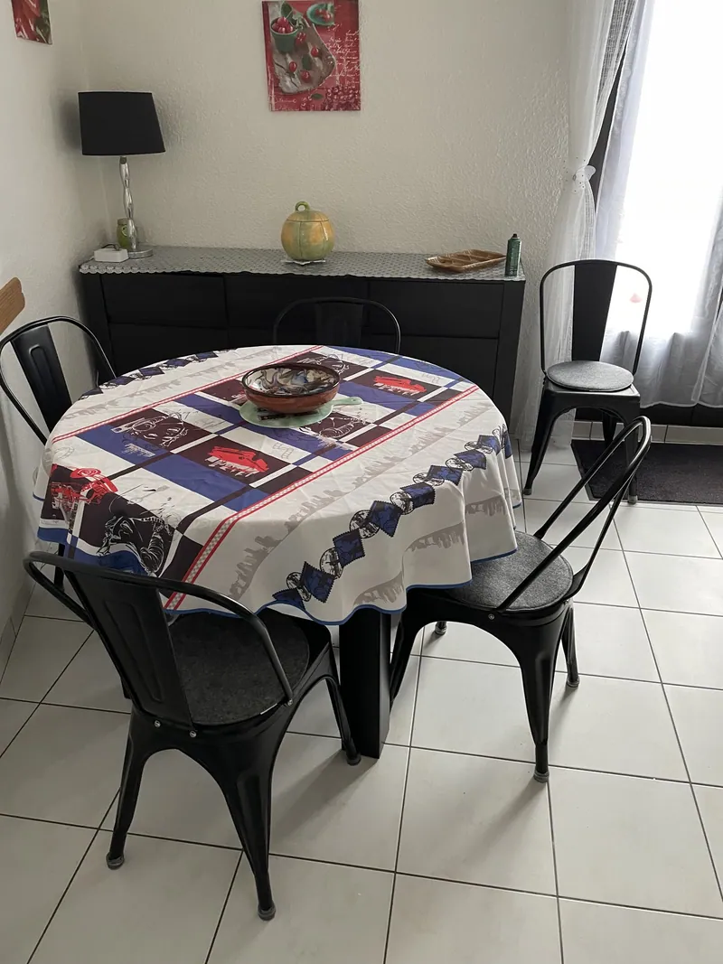 Salle à manger de L'Oustal del Coquillou : table ronde, quatre chaises et buffet